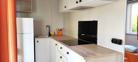 Moderne Küchenzeile im Mobile Home Riviera im Centro Vacanze San Marino, helles Design mit Fenster.