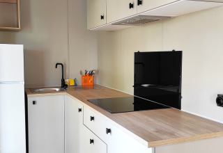 Kitchenette moderne dans le Mobil-home Riviera au Centro Vacanze San Marino, intérieur lumineux et vue fenêtre.