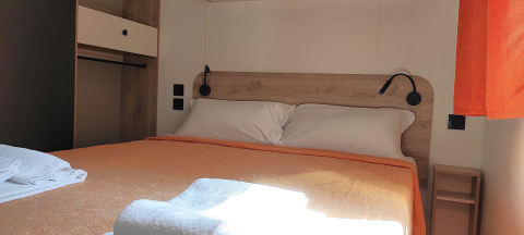 Schlafzimmer im Mobile Home Riviera im Centro Vacanze San Marino mit Doppelbett und Sonnenlicht