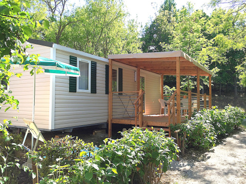 Casa mobile 'Royal' al Centro Vacanze San Marino con veranda in legno e tanto verde intorno.
