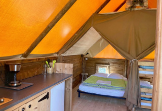Binnenkant van safaritent Glamp tent «2.0» bij Weekend Glamping Resort in Italië, met bedden en kitchenette.