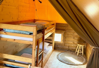Innenaufnahme des Glamp Zeltes 2.0 im Weekend Glamping Resort in Italien mit Etagenbetten aus Holz.