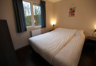 Cozy bedroom at Group Yard Chalets in De Scherpenhof, Netherlands with double bed and window view.