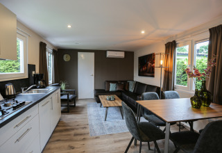 Modern living room and kitchen at Group Yard Chalets, De Scherpenhof, Netherlands, featuring dining area.