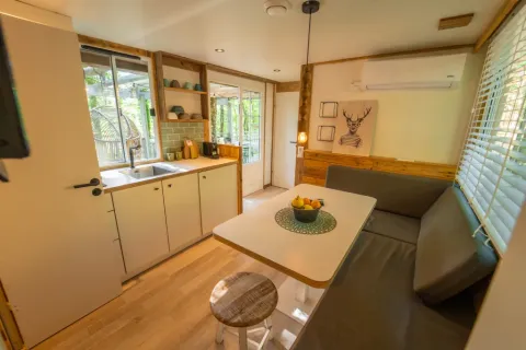 Interieur van de Bohemian Lodge bij Chianti Glamping Resort in Italië, met gezellige keuken en eethoek.