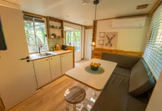 Interieur van de Bohemian Lodge bij Chianti Glamping Resort in Italië, met gezellige keuken en eethoek.