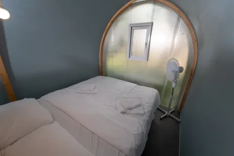 Binnenin een safari-tent Coco Couple bij Chianti Glamping Resort in Italië, met bed en ventilator.