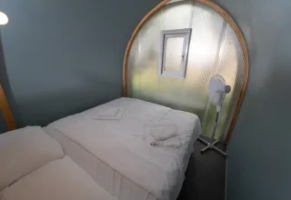 Binnenin een safari-tent Coco Couple bij Chianti Glamping Resort in Italië, met bed en ventilator.