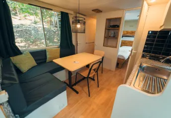 Foto degli interni di soggiorno e cucina nel Cottage Classic al Chianti Glamping Resort in Italia.