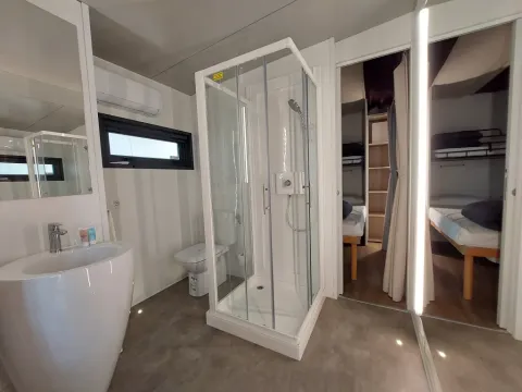 Moderne badkamer met douche en slaapkamers in Cottage Clever bij Chianti Glamping Resort in Italië.