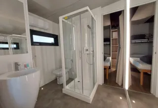 Moderne badkamer met douche en slaapkamers in Cottage Clever bij Chianti Glamping Resort in Italië.