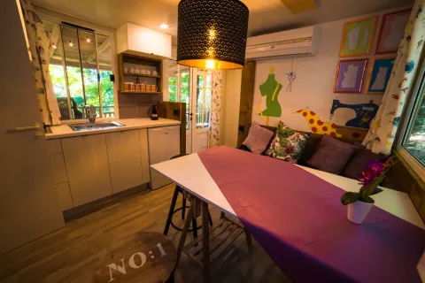 Acogedora cocina y comedor interior en Cottage Spotty del Chianti Glamping Resort, Italia.