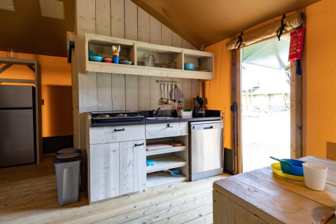Keuken in safaritent De Medley bij Glamping de Bosweide in Nederland, met houten interieur en eethoek.