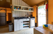 Keuken in safaritent De Medley bij Glamping de Bosweide in Nederland, met houten interieur en eethoek.