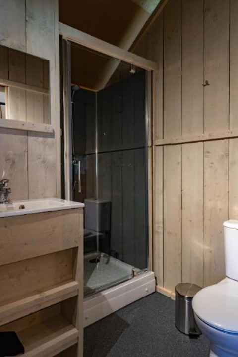 Bagno con doccia, lavandino e WC nella tenda Safari al Glamping de Bosweide, Paesi Bassi.