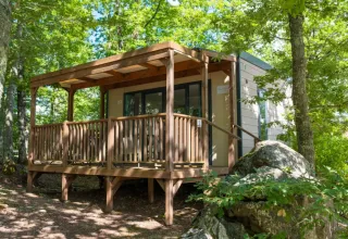 Cube Suite-lodge met houten terras in Chianti Glamping Resort Italië, omringd door groene natuur.