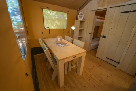 Interieur van een gezellige safaritent eetruimte bij Chianti Glamping Resort in Italië.