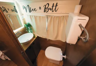 Petite salle de bain dans la tiny house 'Schoolbus' au Chianti Glamping Resort, Italie, avec texte humoristique.
