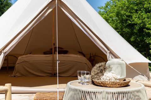 Vista interna di una tenda Bell al Thuysgrond nei Paesi Bassi, con letto pronto e decorazione accogliente.
