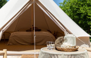 Vista interna di una tenda Bell al Thuysgrond nei Paesi Bassi, con letto pronto e decorazione accogliente.