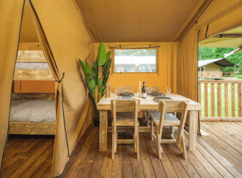 Interieur van Glamp Tent Basic met eettafel en stapelbed bij Weekend Glamping Resort in Italië.
