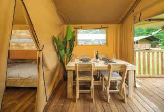 Interieur van Glamp Tent Basic met eettafel en stapelbed bij Weekend Glamping Resort in Italië.