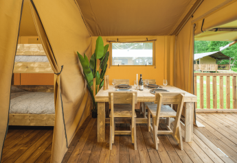 Innenansicht des Glamp Tent Basic mit Esstisch und Etagenbett im Weekend Glamping Resort, Italien.