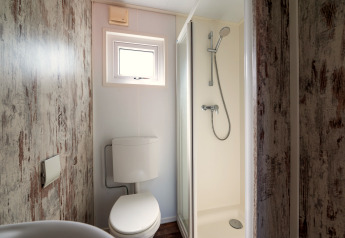 Kleines Badezimmer in der Forest Lodge auf dem Veluwe-Campingplatz De Pampel mit Dusche und WC.