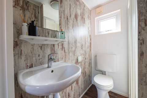 Aseo moderno con lavabo y WC en Forest Lodge, camping Veluwe De Pampel, Países Bajos, decoración rústica.