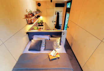 Vue intérieure du Tiny house met spiegelgevel au Holiday park Eigen Wijze avec lit et coin cuisine.