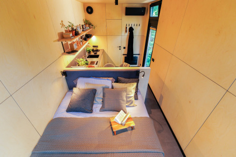Vue intérieure du Tiny house met spiegelgevel au Holiday park Eigen Wijze avec lit et coin cuisine.