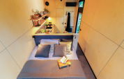 Vista interna di Tiny house met spiegelgevel all’Holiday park Eigen Wijze con letto e cucina moderna.