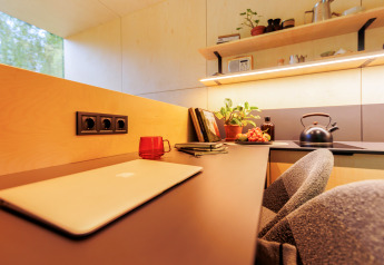 Moderne Tiny House-Küche mit Schreibtisch, Obst, Wasserkocher und Pflanzen auf Holiday park Eigen Wijze.