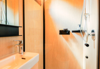 Salle de bain moderne dans une tiny house avec douche et lavabo, Holiday park Eigen Wijze, Pays-Bas.