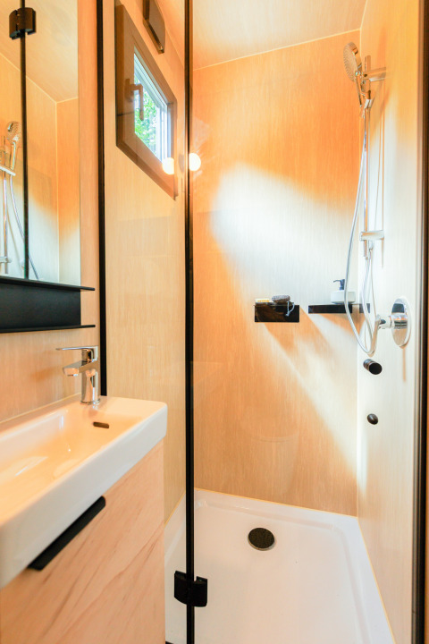 Bagno moderno in tiny house con doccia e lavandino presso Holiday park Eigen Wijze, Paesi Bassi.