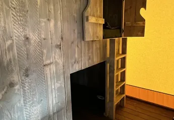 Intérieur d'une tente safari de luxe à Outdoor Centre Hessenheem, Pays-Bas, avec murs et mezzanine bois.