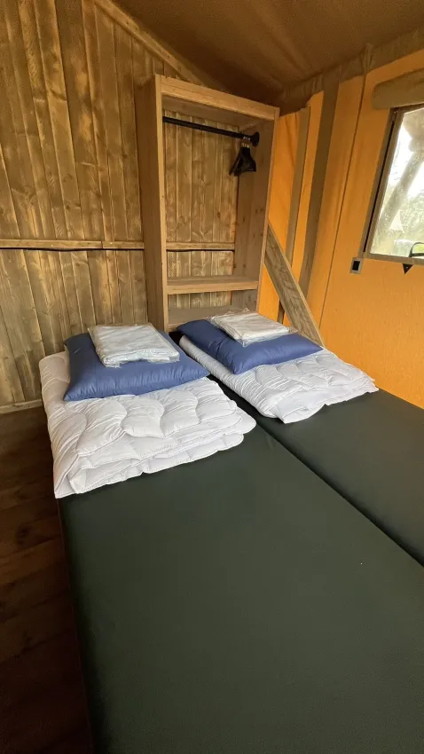 Tweepersoonsbed in de Luxury Safari tent bij Outdoor Centre Hessenheem, Nederland, met beddengoed.