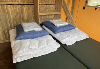 Double bed setup in the Luxury Safari tent at Outdoor Centre Hessenheem, Netherlands, with bedding.