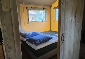 Vista interior de un dormitorio en tienda safari de lujo en Outdoor Centre Hessenheem, Países Bajos.