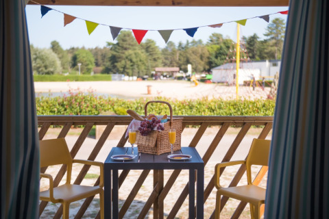 Vista dalle Beach Lodges ad Arden Parks Tulderheyde, Belgio, con tavolo, cestino da picnic e spiaggia sabbiosa.