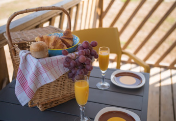 Cestino della colazione con croissant, uva e succo su tavolo ai Beach Lodges, Arden Parks Tulderheyde, Belgio.