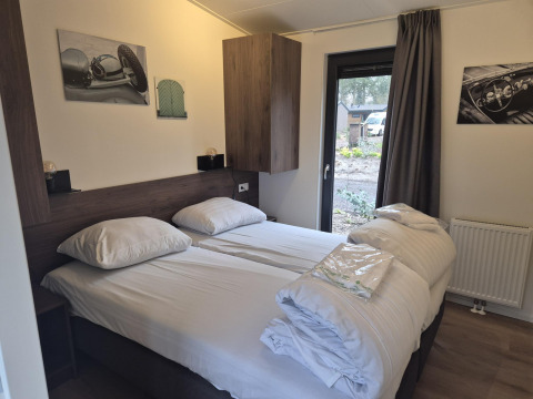 Soveværelse i Cube Lodge 4 i De Utrechtse Heuvelrug, Nederlandene, med to enkeltsenge og moderne indretning.
