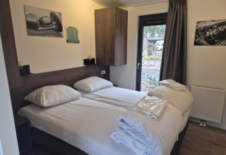 Soveværelse i Cube Lodge 4 i De Utrechtse Heuvelrug, Nederlandene, med to enkeltsenge og moderne indretning.
