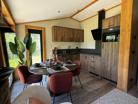 Cuisine moderne et coin repas dans Arlberg Cabin à Austriaparks Camping Arlberg, Autriche, avec accents boisés.