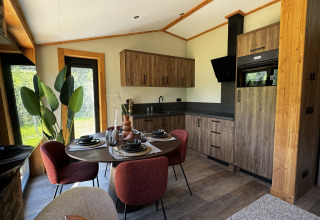 Cuisine moderne et coin repas dans Arlberg Cabin à Austriaparks Camping Arlberg, Autriche, avec accents boisés.