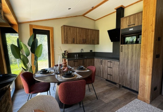 Cuisine moderne et salle à manger à l’Arlberg Cabin d’Austriaparks Camping Arlberg, Autriche, vue sur jardin.