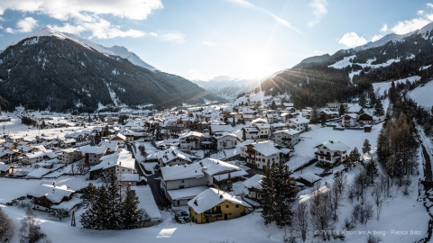 Vue hivernale de l’Arlberg Cabin à Austriaparks Camping Arlberg, entourée de montagnes enneigées en Autriche.