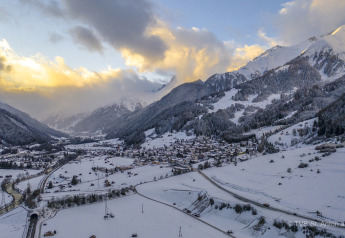 Valle y montañas nevadas al atardecer, vista desde Arlberg Cabin en Austriaparks Camping Arlberg, Austria.
