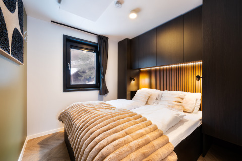 Modern slaapkamer in Stanzertal Cabin, Austriaparks Camping Arlberg, Oostenrijk, met stijlvolle, warme inrichting.