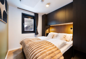 Dormitorio moderno en Stanzertal Cabin, Austriaparks Camping Arlberg, Austria, con decoración elegante y acogedora.